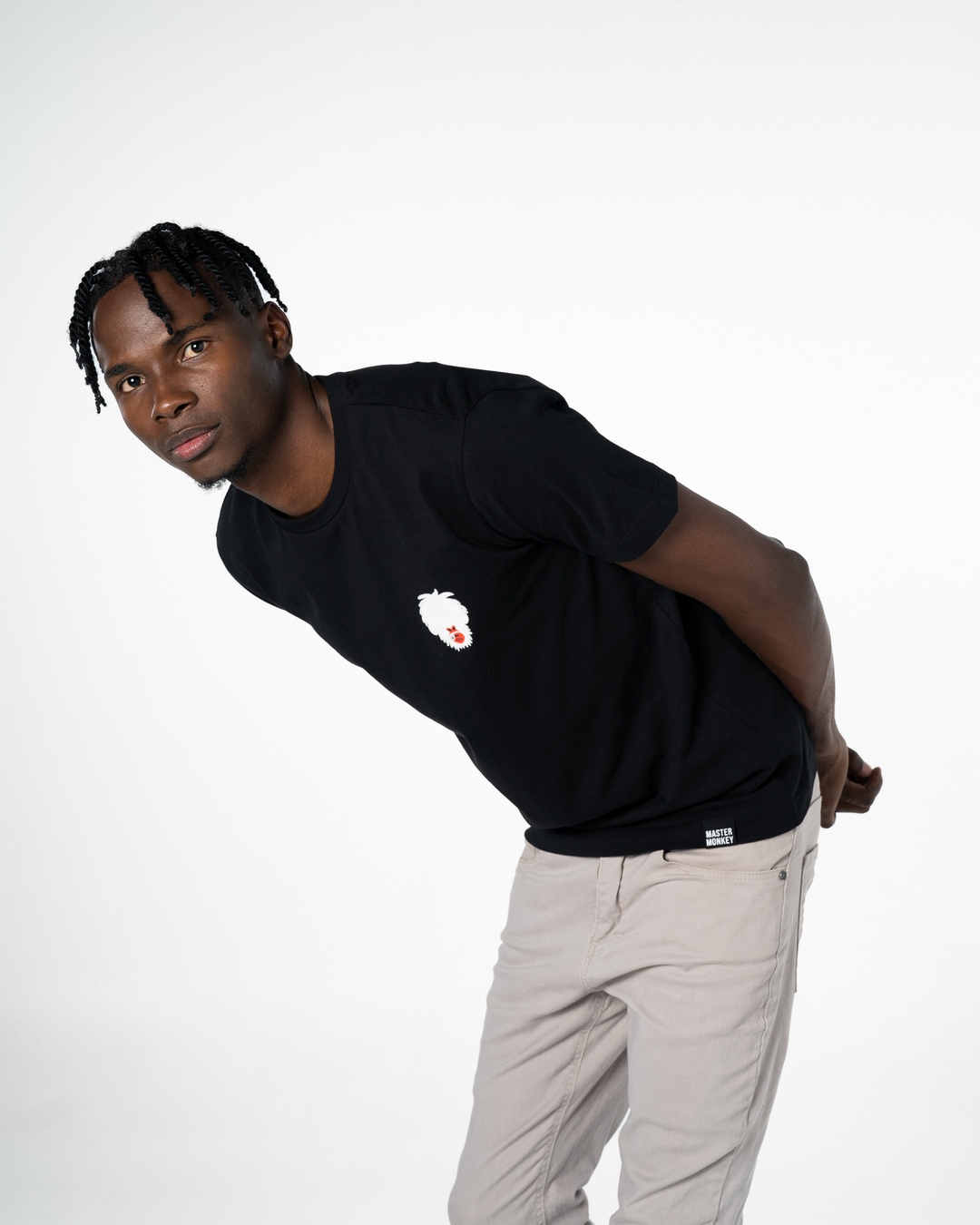 Man wearing a black t-shirt with a Master Monkey logo and light gray pants on a white background #color_black