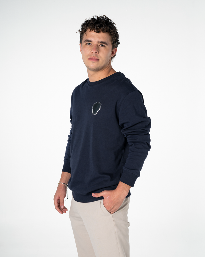 Man wearing a navy blue sweatshirt with a  silver foil Master Monkey logo design on a white background #color_midnight