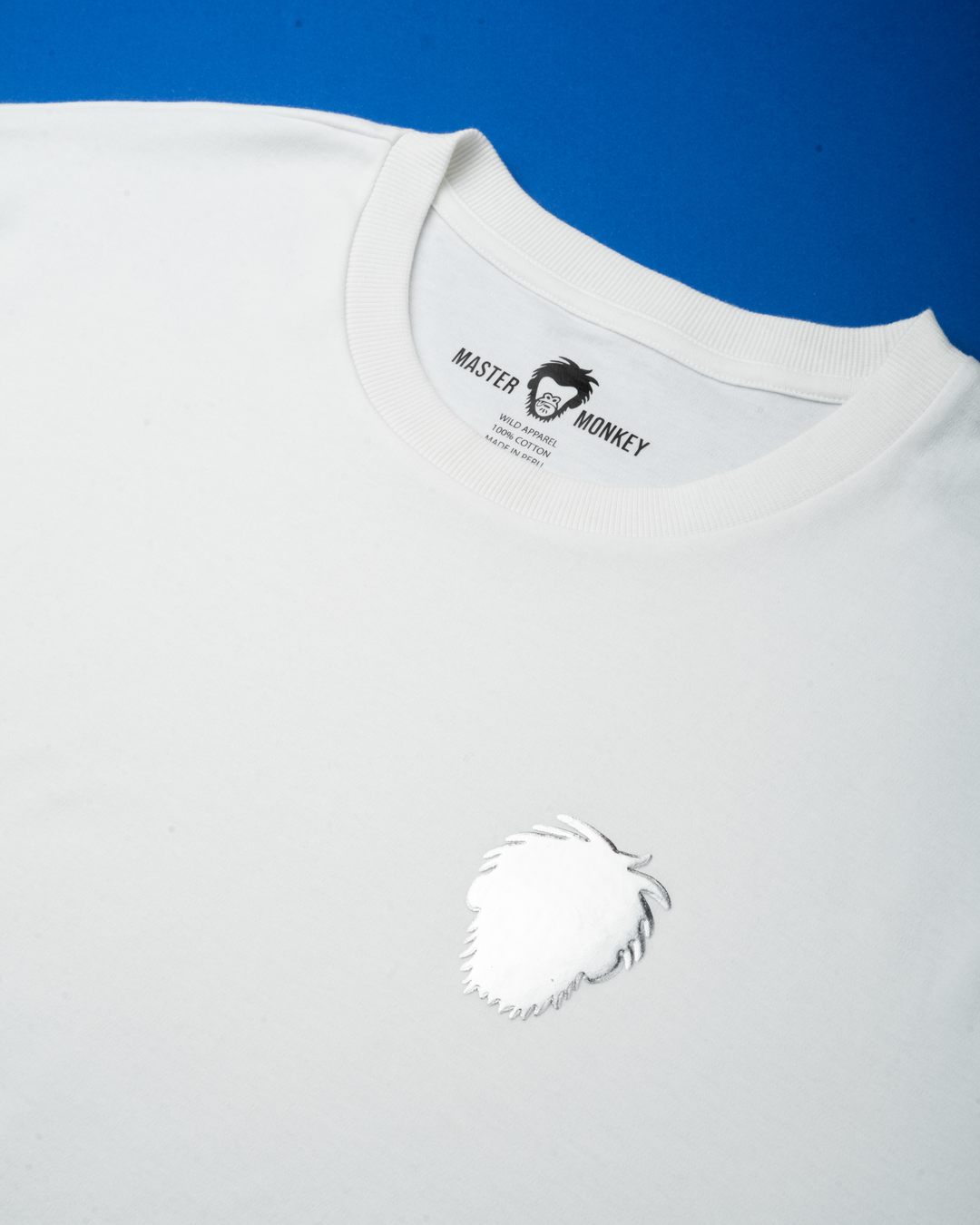 White t-shirt with a silver foil master monkey logo on a blue background #color_white