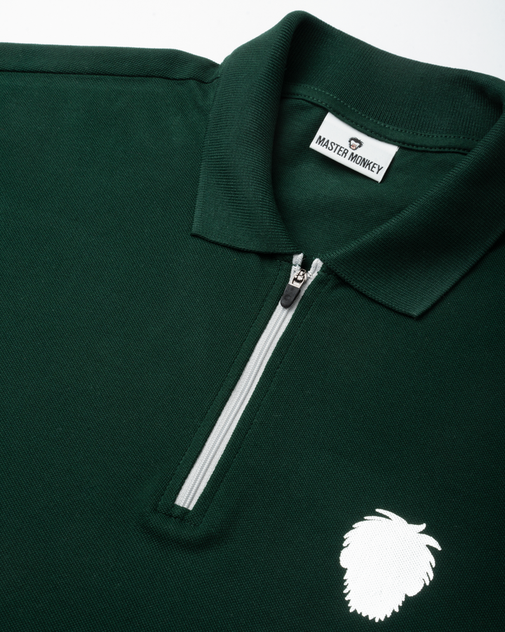 Green polo shirt with a zipper and reflective logo on a white background #color_gunmetal-green