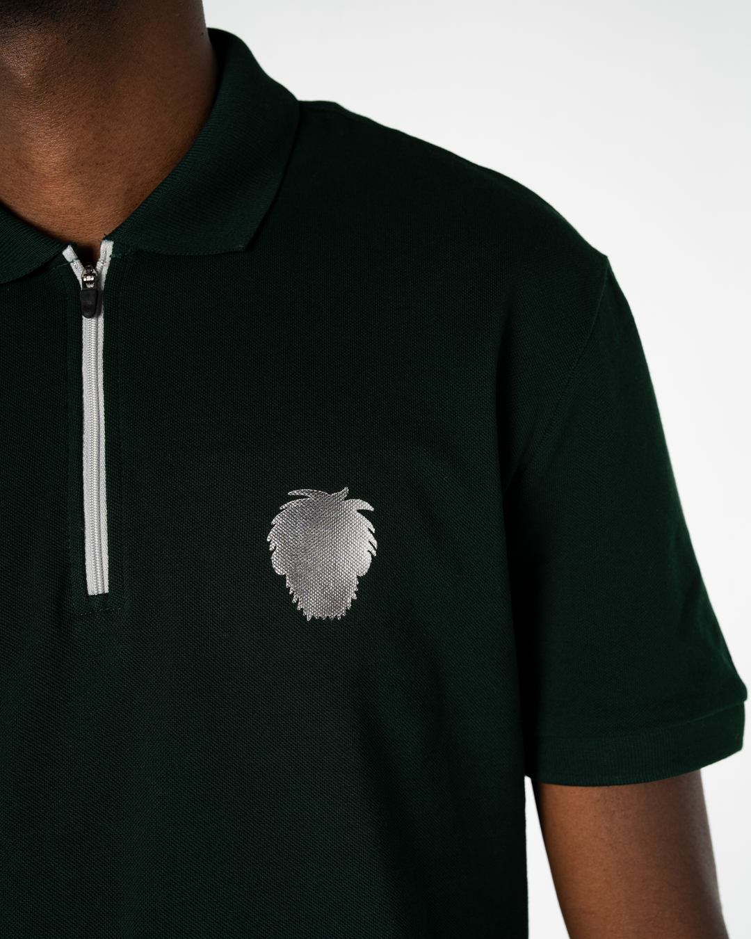 Black polo shirt with a small logo on a white background #color_gunmetal-green