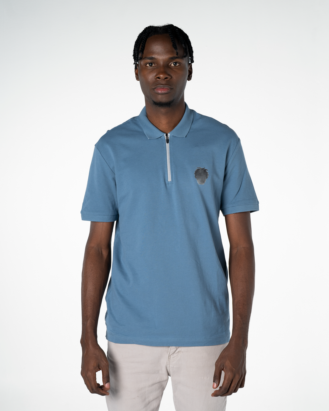 Man wearing a light blue polo shirt with a small logo on a white background #color_steel-blue