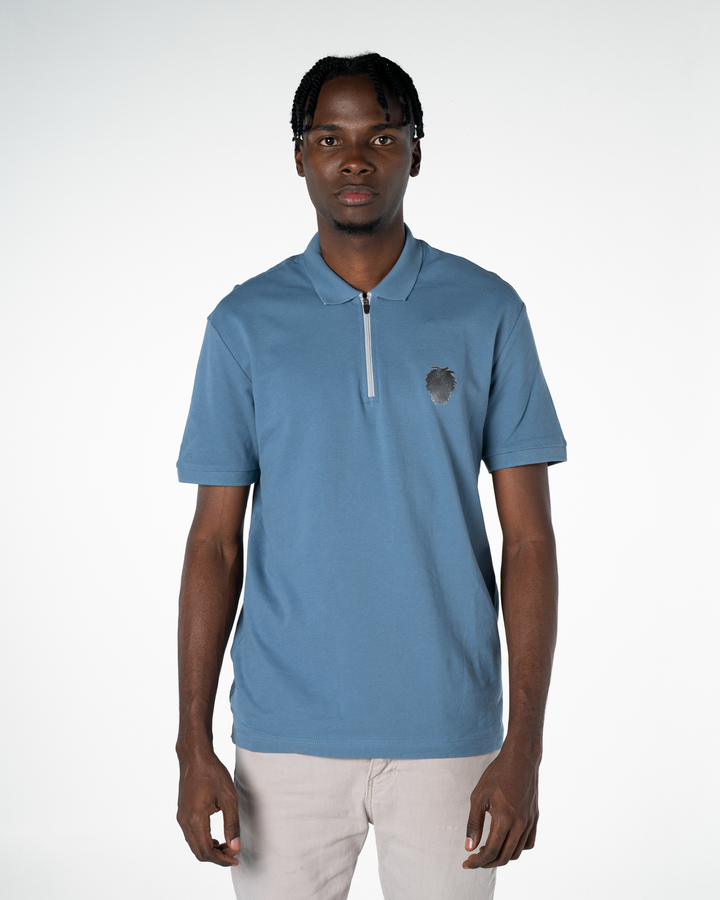 Man wearing a light blue polo shirt with a small logo on a white background #color_steel-blue