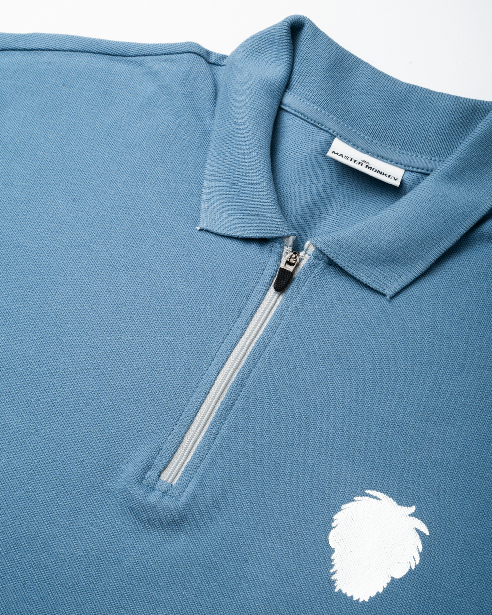 Blue polo shirt with a reflective logo on a white background #color_steel-blue