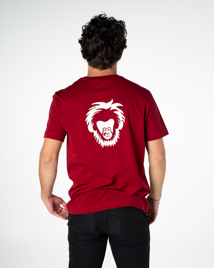 Person wearing a red t-shirt with a white graphic on the back against a white background #color_brick