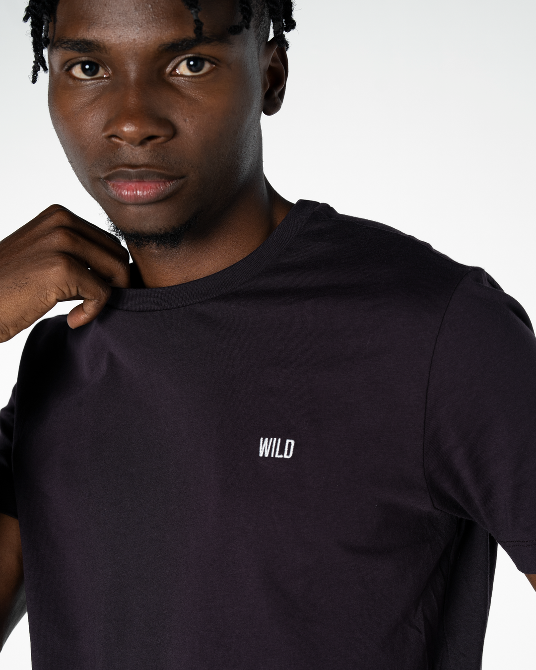Person wearing a purplish grey t-shirt with 'WILD' logo on a white background #color_lead