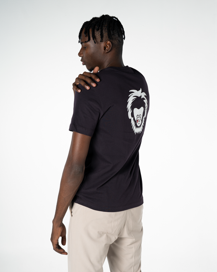 Person wearing a black t-shirt with a white logo on the back, standing against a plain background #color_lead