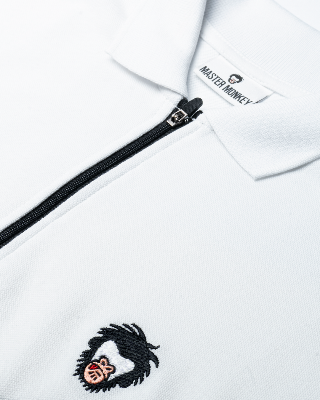 Close up of Master Monkey polo in White. #color_white