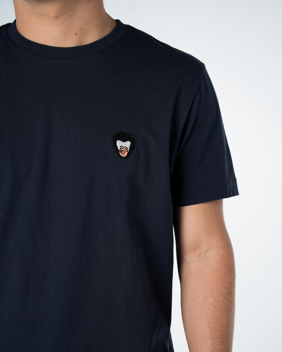 Black t-shirt with a small embroidered Master Monkey design on a white background #color_midnight