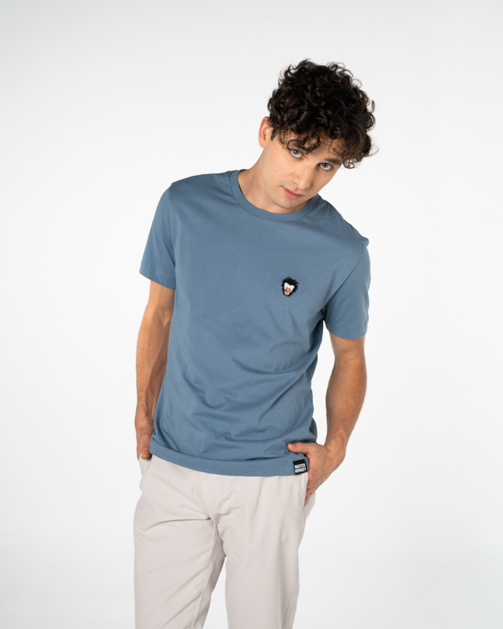 Person wearing a blue t-shirt with a small Master Monkey logo on a white background #color_steel-blue