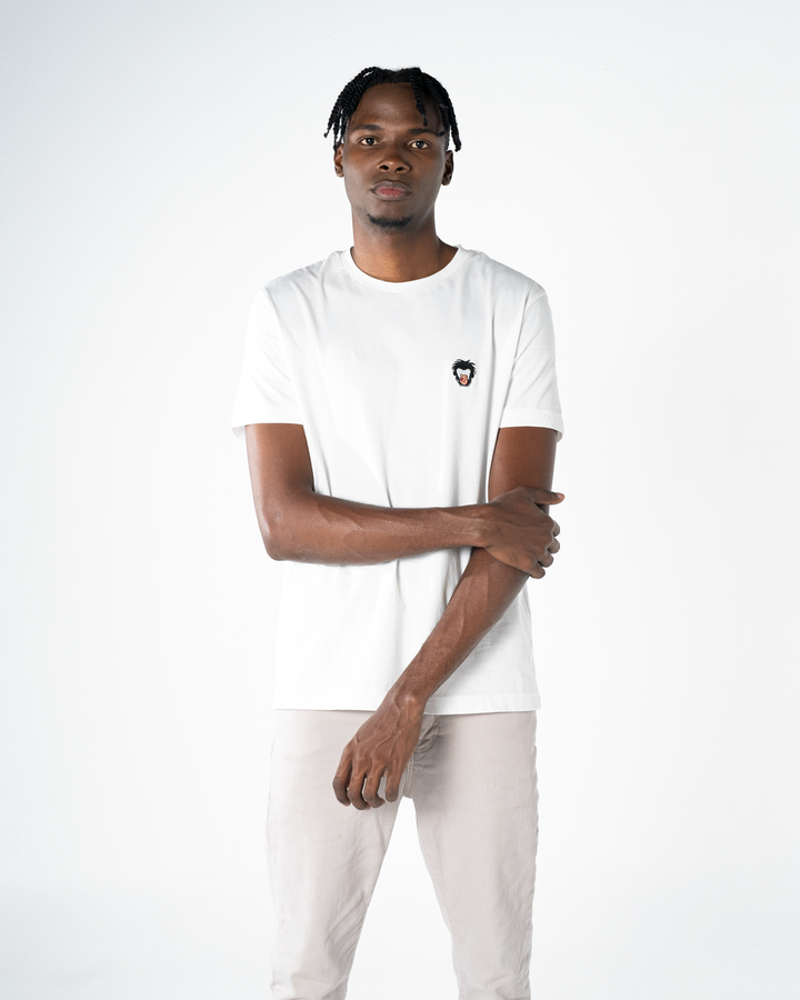 Person wearing a white t-shirt with a small logo on a plain background #color_white