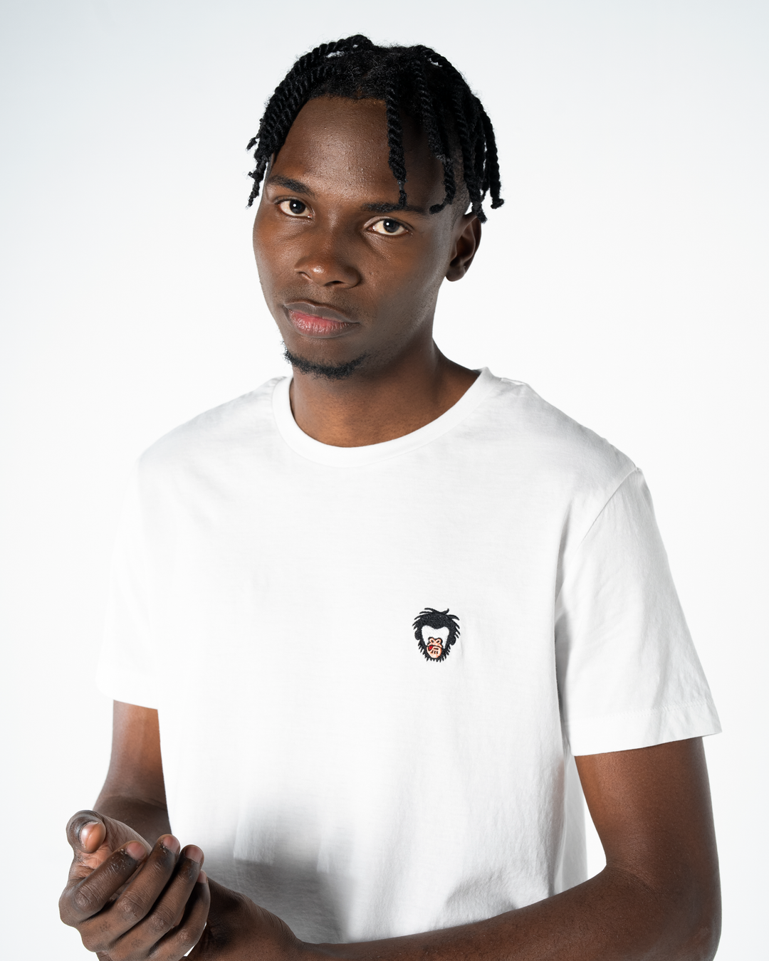 Person wearing a white t-shirt with a small graphic on a white background #color_white