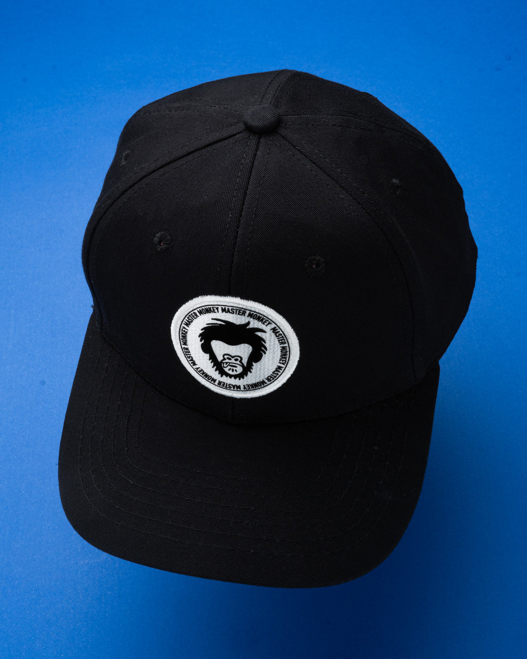 Black cap with a white logo on a blue background #color_black