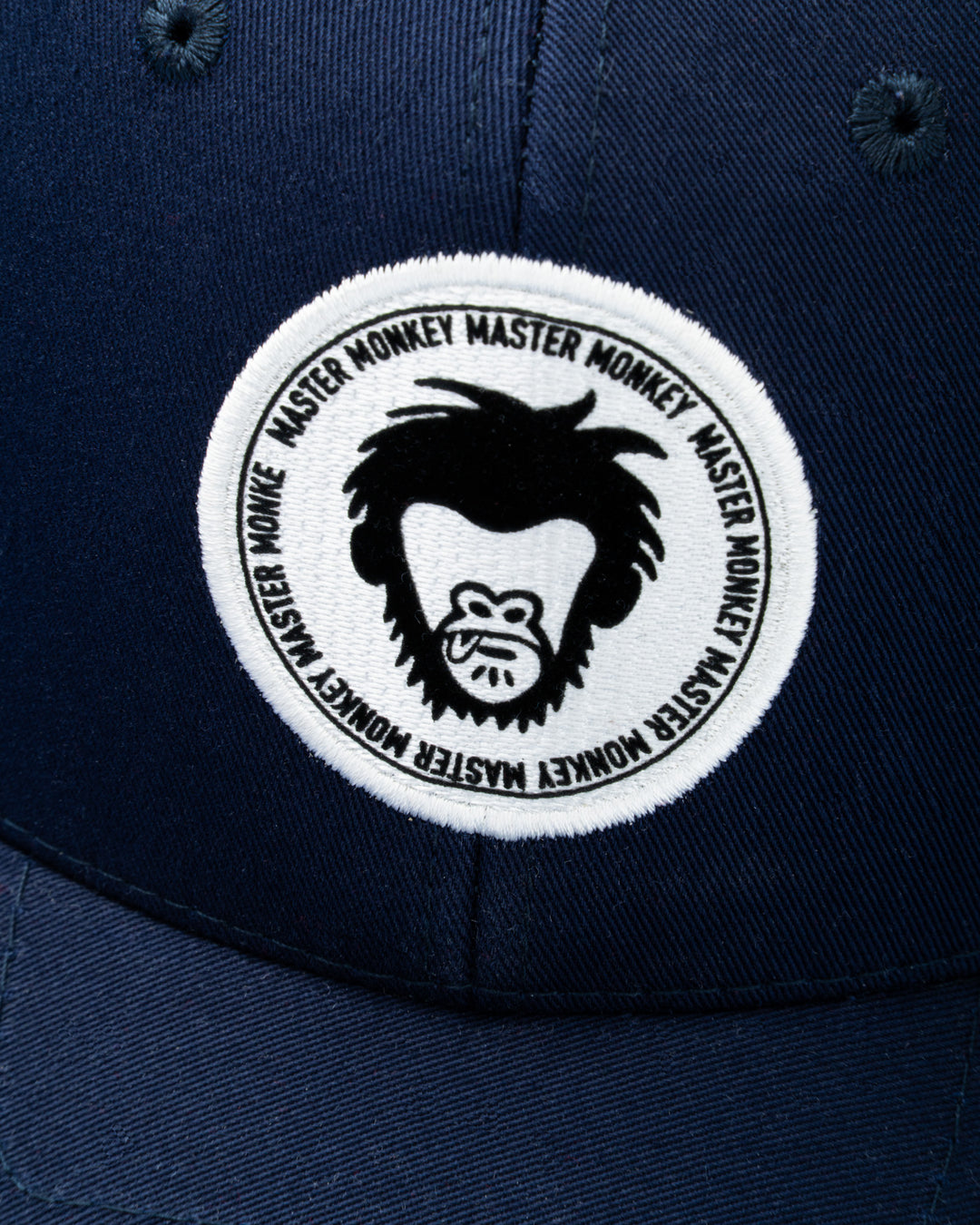 Navy blue cap with a white patch featuring a black monkey logo and text. #color_midnight